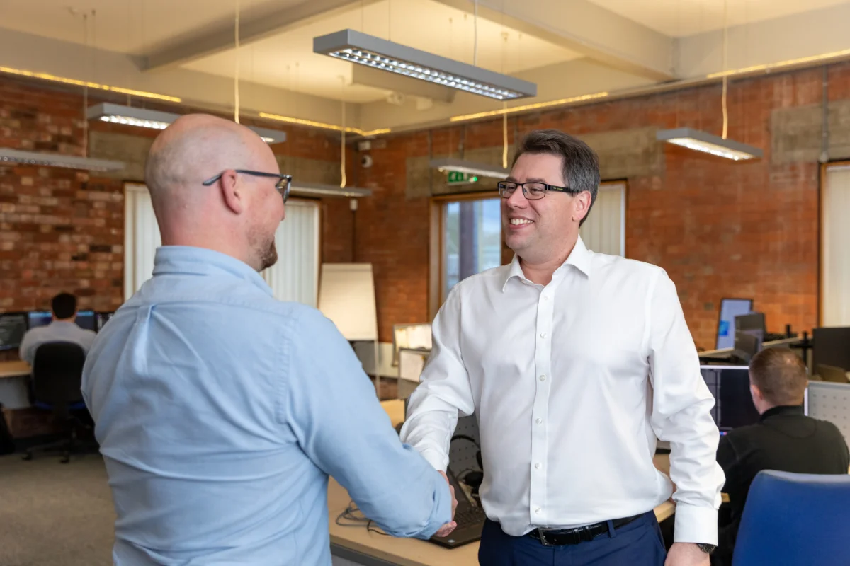 Director Chris shaking hands with prospect in Syscomm office Coventry