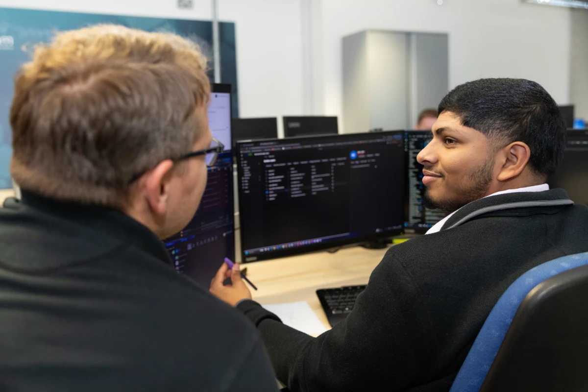 Two Syscomm team member working together on the computer
